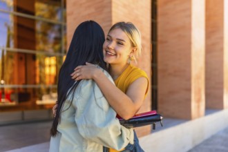 Student greeting a university mate and embracing her at the campus