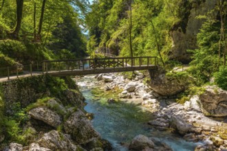 Turquoise water flowing under wooden bridge over tolmin gorges in triglav national park, slovenia