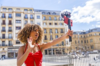 Brunette woman recording life video streaming with mobile outdoors in the city