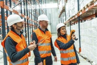 Warehouse workers utilizing barcode scanners and diligently taking notes during logistics