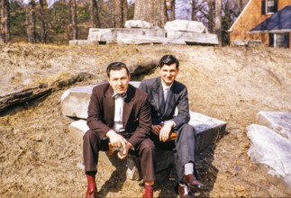 Two elegantly dressed men sitting outside and looking into the camera, USA around 1953