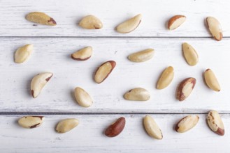 Pattern and texture made from Brazil nuts on white wooden background, flat lay. top view