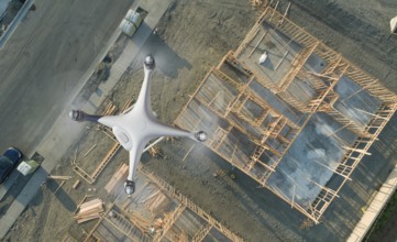 Unmanned aircraft system quadcopter drone UAV in the air over construction site.