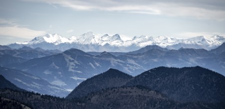 View of the Alpine foothills and main Alpine ridge with snow-covered peaks, summit of the Hohe