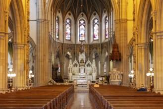 Magnificent interior of a church with a view of the altar and ornate Gothic arches under a warm