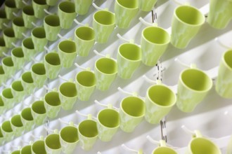 Green drinking cups hanging in an IKEA store create abstract pattern