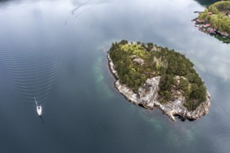 Aerial view topdown on island and sailing boat in the Lysefjord, just north of the Lysefjod bridge,