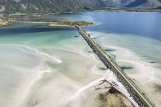 Aerial view of a bridge over turquoise sea at a sandy beach, fjord Grunnforfjorden, Lofoten