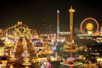 Street of beer tents, main street at night with illuminated roller coaster, Ferris wheel, stalls,