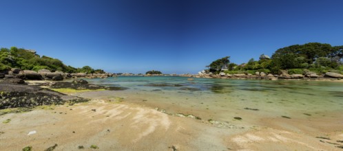 Beach with rocks and sand at the Plage Saint Guirec, with clear blue sky and colors as in the