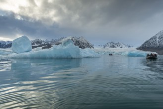 Dinghy with tourists, icebergs in front of glacier, -edge of Monacobreen, Liefdefjord, Woodfjord