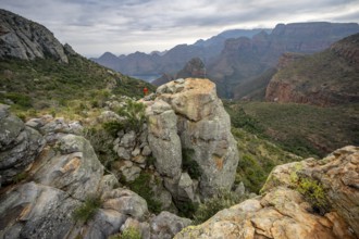 Young man on a rock, view of Blyde River Canyon with Mesa mountains, Upper Viewpoint, canyon