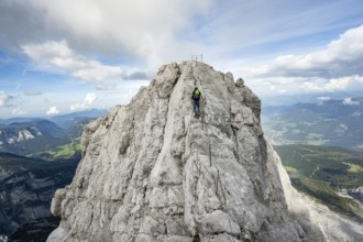 Mountaineer on a narrow rocky ridge on a steel cable, Watzmann crossing to Watzmann Mittelspitze,