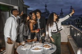 Woman taking selfie during night party in a rooftop with multi-ethnic friends
