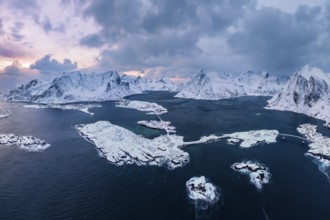 View of snow-covered islands, fjord and mountains, fishing villages Sakrisøy and Reine, Reinefjord,