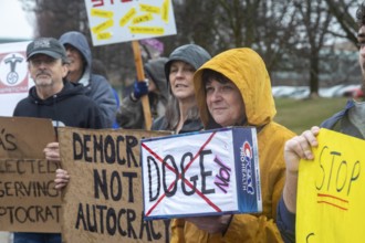 Troy, Michigan USA - 29 March 2025 - People gathered in the rain outside the Tesla Showroom at the