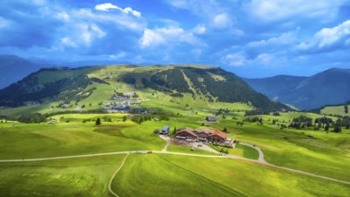Stunning aerial view capturing green meadows, traditional houses, and rolling hills beneath a