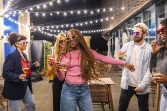 Happy modern african woman with long braided hair dancing with multi-ethnic friends at night party
