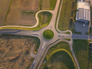 Aerial view of a roundabout surrounded by fields and buildings in the evening sun, Nagold, Black