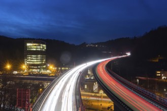 Federal road B14 at night, road bridge with traffic and light lanes. On the left the building of