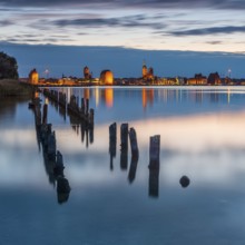 View at dusk over the Strelasund to the illuminated town of Stralsund with its churches and the