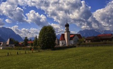Idyllic village with church and mountains in the background under a blue sky, Wallgau, Bavaria,