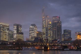 Low clouds envelop the shining towers of Frankfurt's banking skyline in the evening. Frankfurt am
