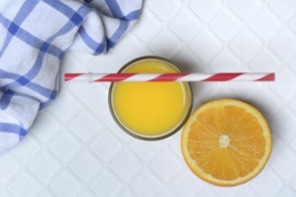 Orange juice in glass and orange, straw