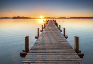 Jetty at Wörthsee at sunrise, fog on the water, Bavaria, Germany, Europe