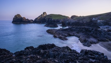 Kynance Cove with Asparagus Island, with sea, sandy beach and rocks in the evening at sunset.