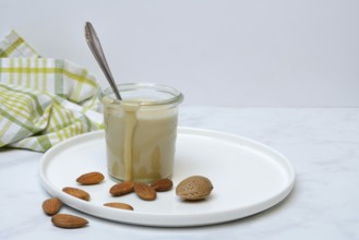 Almond cream in a jar and almonds