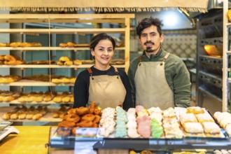 Portrait of a couple of latin young artisans bakery shop owners