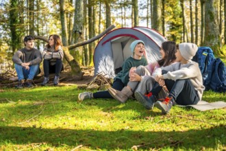 Caucasian family with three children sitting enjoying nature during a day camping at forest