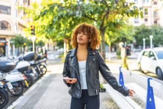 Latin woman enjoy the city walking and listening to music using phone