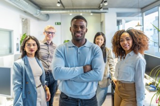 Diverse group of professionals standing together in a modern coworking space, showcasing teamwork