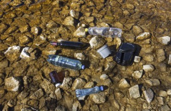 Environmental pollution, Household waste washed up on the lake shore, Plastic and glass bottles,