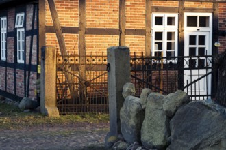 Evening light shines on a driveway and the façade of a half-timbered house, Otersen, Kirchlinteln,