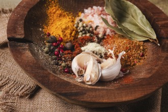 Spice mix, garlic and bay leaf, on a wooden plate, close-up, food concept, no people