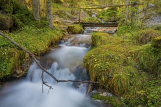 View of a wooden bridge leading over a torrent, long exposure, Dolomites, Puez-Geisler nature park