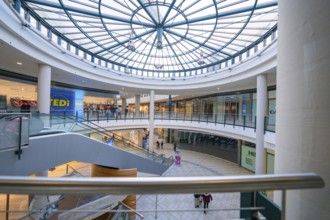 Interior of a large shopping centre with a large glass roof and escalator, Sterncenter