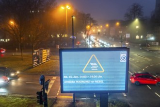 Dense fog, with visibility partly below 100 metres, city centre traffic at rush hour on