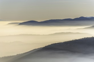 The mountains are shrouded in mist and the sky is a mixture of blue and white. The bleak atmosphere