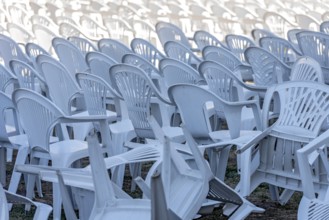 Seating for outdoor event, rows of chairs, overturned garden chairs made of plastic, plastic,
