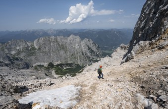 Mountaineer with helmet in rocky mountain landscape, descent to the Grieskarscharte, crossing the