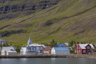 Blue and red houses in Seydisfjordur village on a bright sunny day. E Iceland