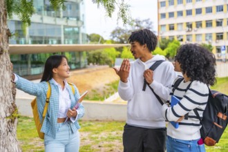 Three quarter length photo of three multi-ethnic friends talking standing together in the