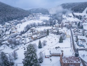 Snow-covered village in a valley surrounded by wooded hills, Enzklösterle, district of Calw, Black