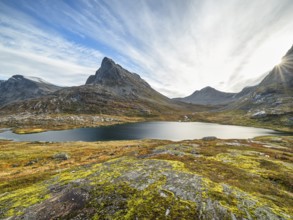 Lake Alnesvatnet with sun star in autumn, mountain Vestre Stigbotthornet in the background,