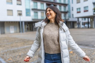 Caucasian happy woman wearing warm clothes enjoying dancing alone in the city