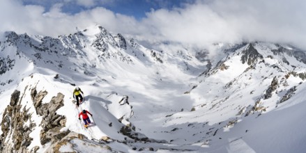 Two mountaineers climbing the narrow ridge of Piz Laviner, view of mountain panorama in winter